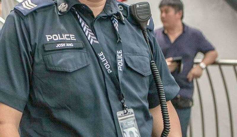 Police officer in uniform with radio and identification badge